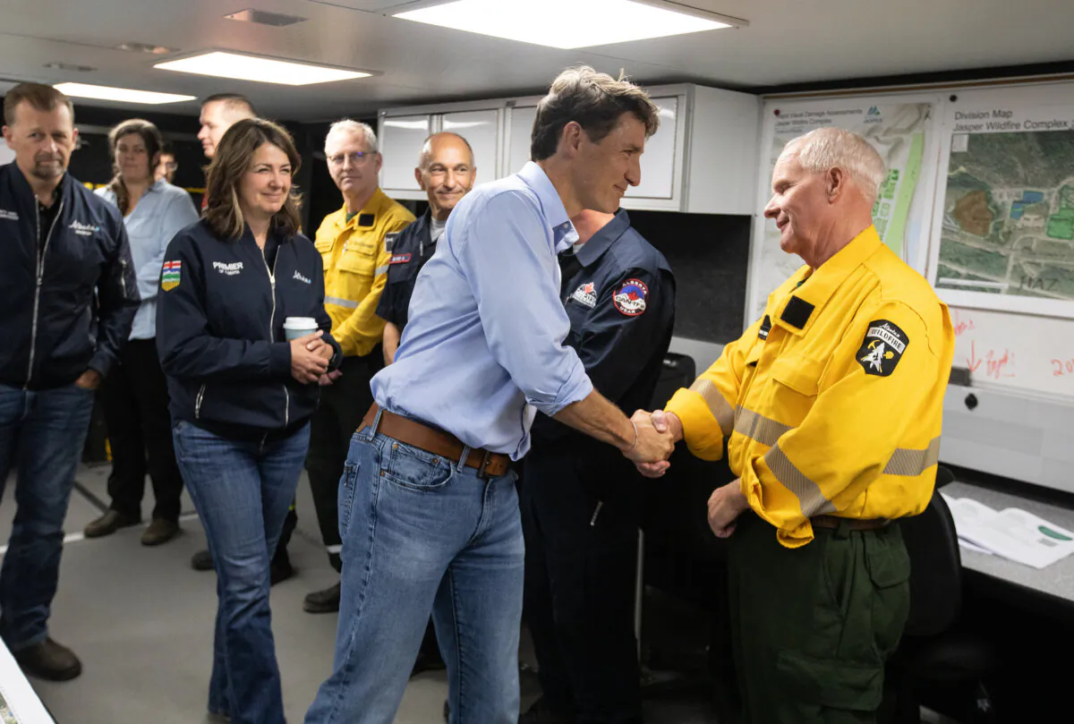 Prime Minister Justin Trudeau and Alberta Premier Danielle Smith meet with wildfire workers while visiting the wildfire command centre in Hinton, Alta., on Aug. 5, 2024. (THE CANADIAN PRESS/Jason Franson)