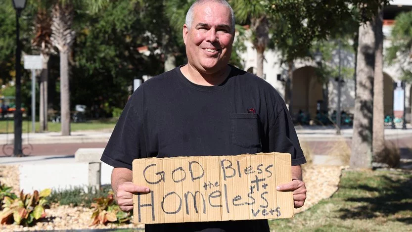 Jeff Gray holds the sign "God Bless the Homeless Vets" that led to his arrest and ultimate victory in a lawsuit. (Courtesy of Lacy Jessica Photography)