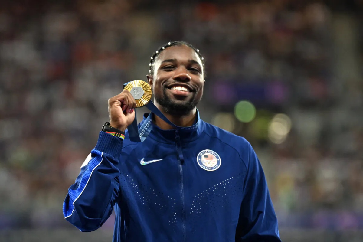 Gold medalist Noah Lyles of Team USA celebrates on the podium during the victory ceremony for the men's 100 meters during the Paris Olympics on Aug. 5, 2024. (Martin Bernetti/AFP via Getty Images)