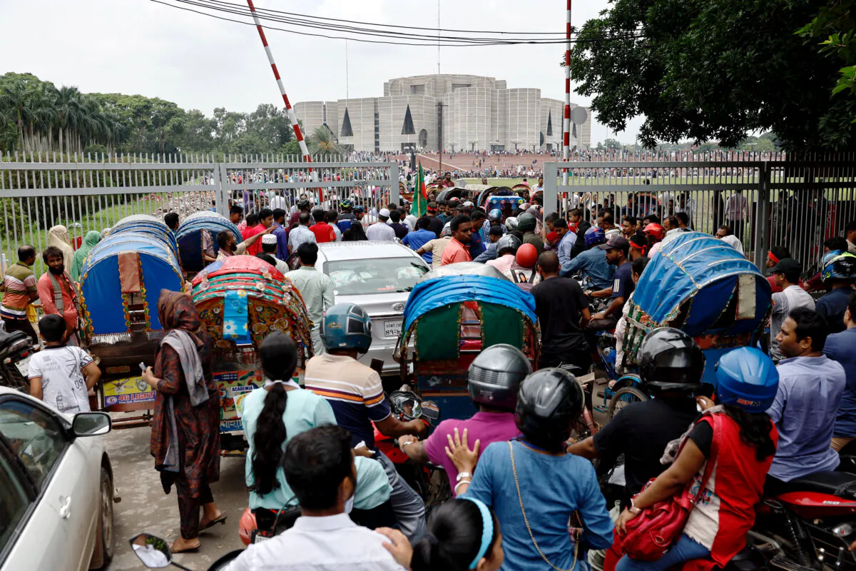 People and vehicles cram at the gate as they gather outside the parliament building, a day after the resignation of Bangladeshi Prime Minister Sheikh Hasina, in Dhaka, Bangladesh, on Aug. Aug. 6, 2024. (Mohammad Ponir Hossain/Reuters)
