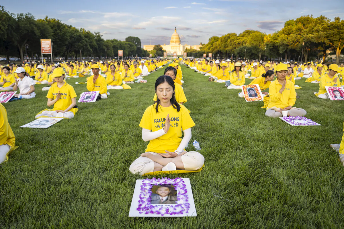 Falun Gong practitioners gather at the National Mall in Washington for a candlelight vigil commemorating the persecution of Falun Gong in China by the Chinese Communist Party on July 11, 2024. (Madalina Vasiliu/The Epoch Times)