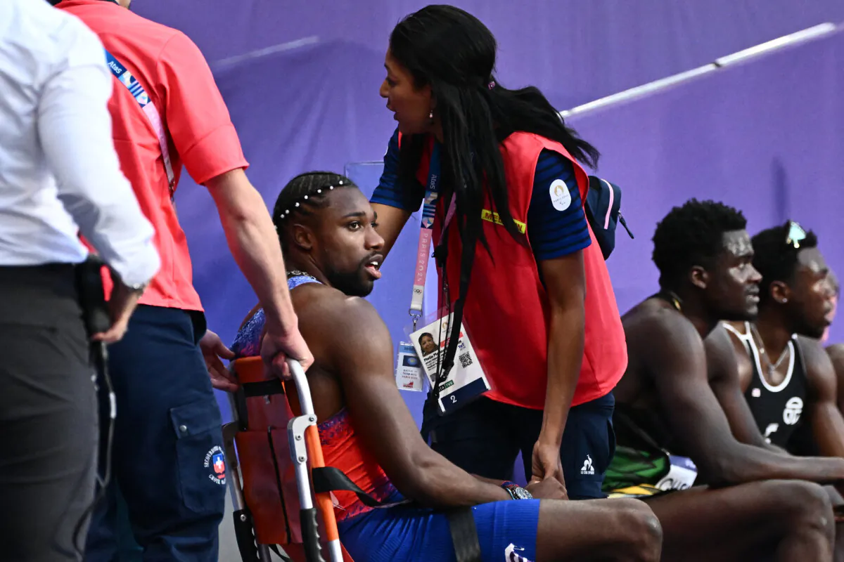 Bronze medallist Noah Lyles of Team United States receives medical attention after competing in the men's 200m final of the athletics event at the Paris 2024 Olympic Games at Stade de France in Saint-Denis, north of Paris, on Aug. 8, 2024. (Jewel Samad/AFP via Getty Images)