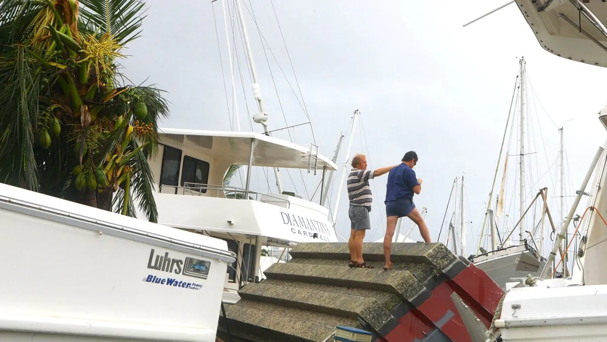 Boat owners survey damage at the local marina in Port Hinchinbrook, Australia on Feb. 4, 2011. (Jonathan Wood/Getty Images)