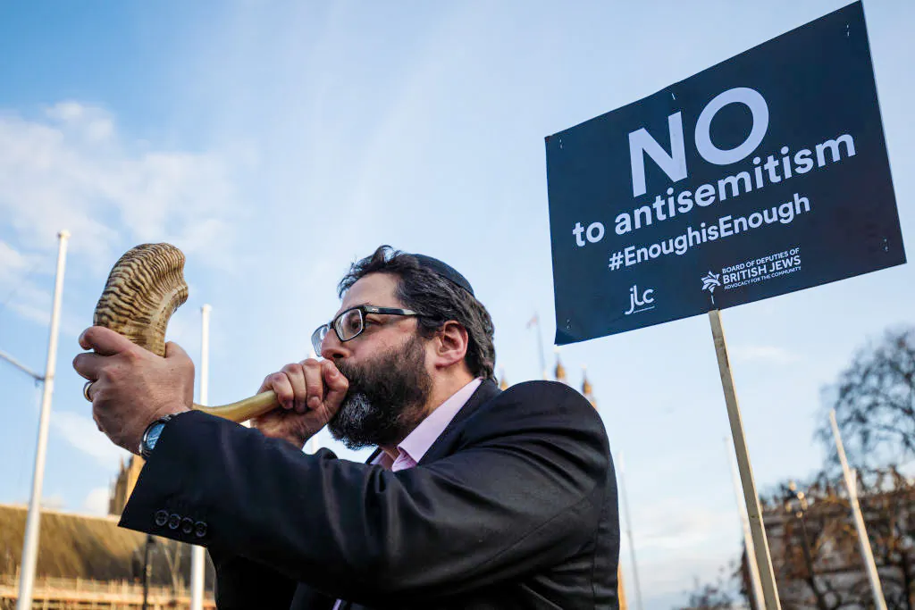 A protester blows through a shofar during a demonstration in Parliament Square against antisemitism in Jeremy Corbyn's Labour Party, in London on March 26, 2018. (Jack Taylor/Getty Images)