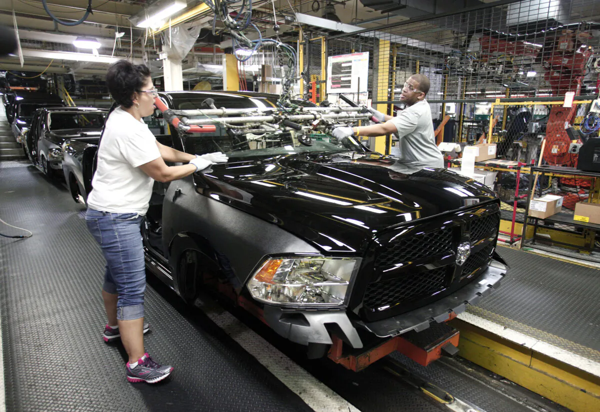 Workers install a windshield into a Ram 1500 truck on the assembly line at the Warren Truck Assembly Plant in Warren, Mich., on Sept. 25, 2014. (Bill Pugliano/Getty Images)