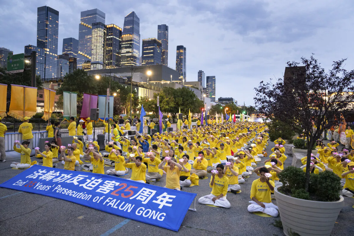 Falun Gong practitioners take part in a candlelight vigil in memory of Falun Gong practitioners who passed away during 25 years of ongoing persecution by the Chinese Communist Party, at the Chinese consulate in New York City on July 20, 2024. (Larry Dye/The Epoch Times)
