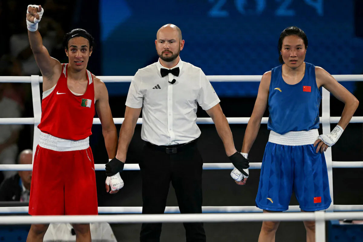 Algeria's Imane Khelif reacts after beating China's Yang Liu (Blue) in the women's 66kg final boxing match during the Paris 2024 Olympic Games at the Roland-Garros Stadium, in Paris on Aug. 9, 2024. (Mauro Pimentel/AFP via Getty Images)