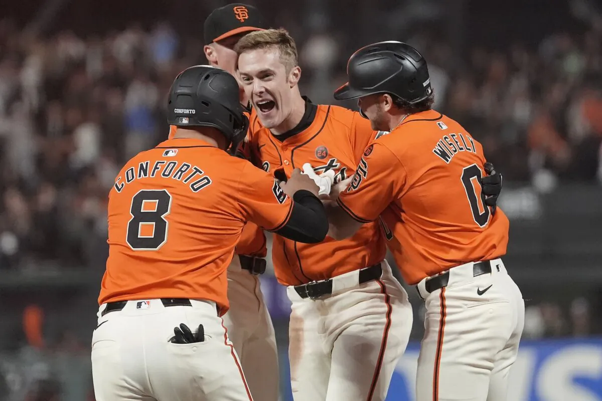 San Francisco Giants' Mark Canha, middle, is congratulated by teammates after hitting a sacrifice fly that scored Michael Conforto (8) for the winning run during the ninth inning of a baseball game against the Detroit Tigers in San Francisco on Aug. 9, 2024. (Jeff Chiu/AP Photo)