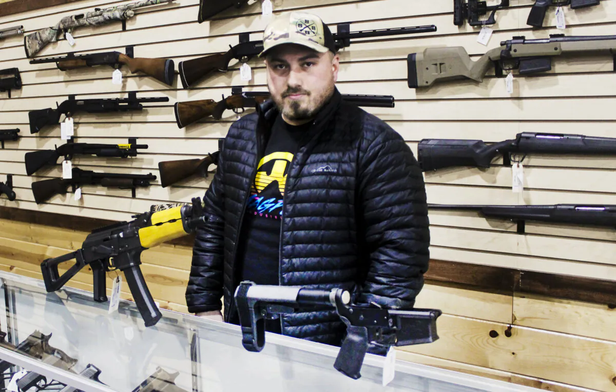 Justin Barrett, owner of Barrett Outdoors in Durant, Okla., displays some pistol stabilizing braces. (Michael Clements/The Epoch Times)