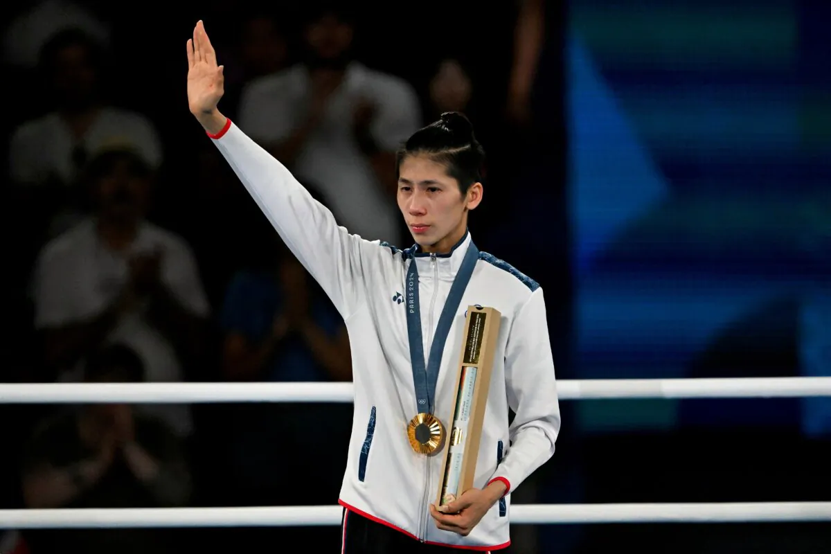 Gold medallist Taiwan's Lin Yu-ting celebrates on the podium during the medal ceremony for the women's 57kg final boxing category during the Paris 2024 Olympic Games at the Roland-Garros Stadium in Paris on Aug. 10, 2024. (Mohd Rasfan/AFP via Getty Images)