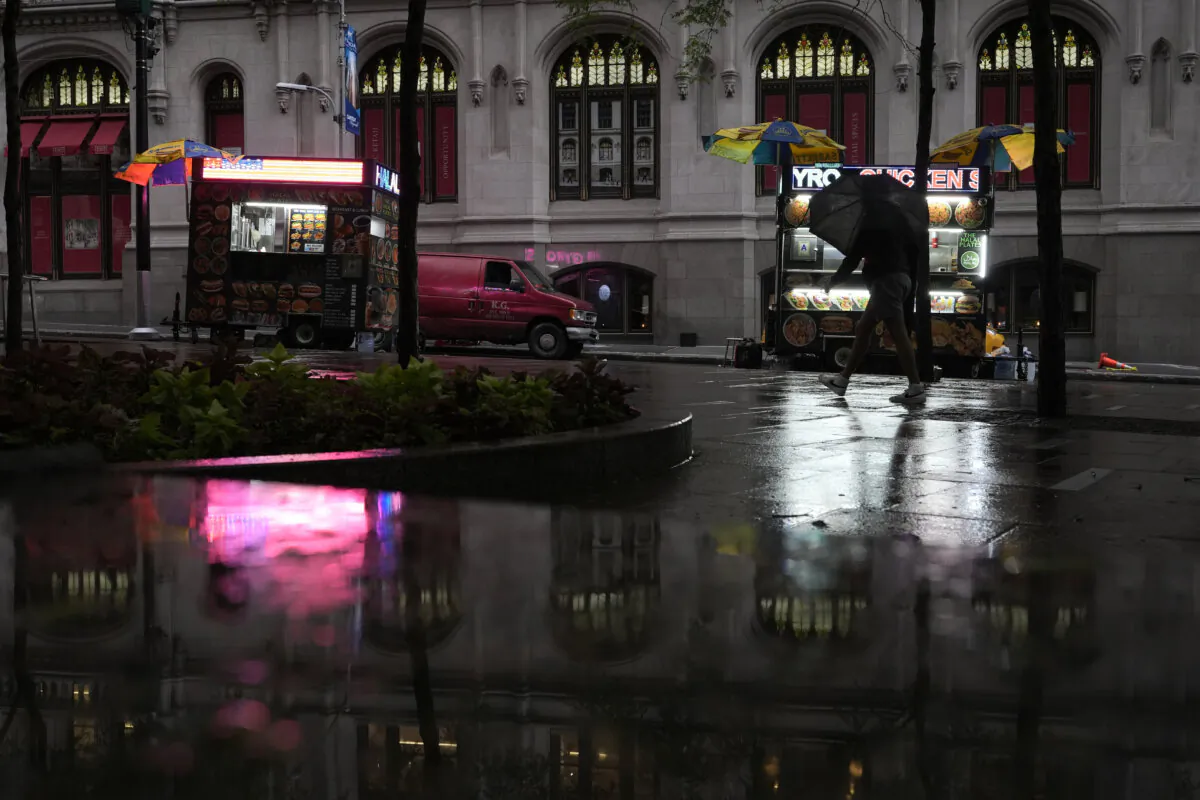 A person with an umbrella walks in the rain in New York, on Aug. 9, 2024. (Pamela Smith/AP Photo)