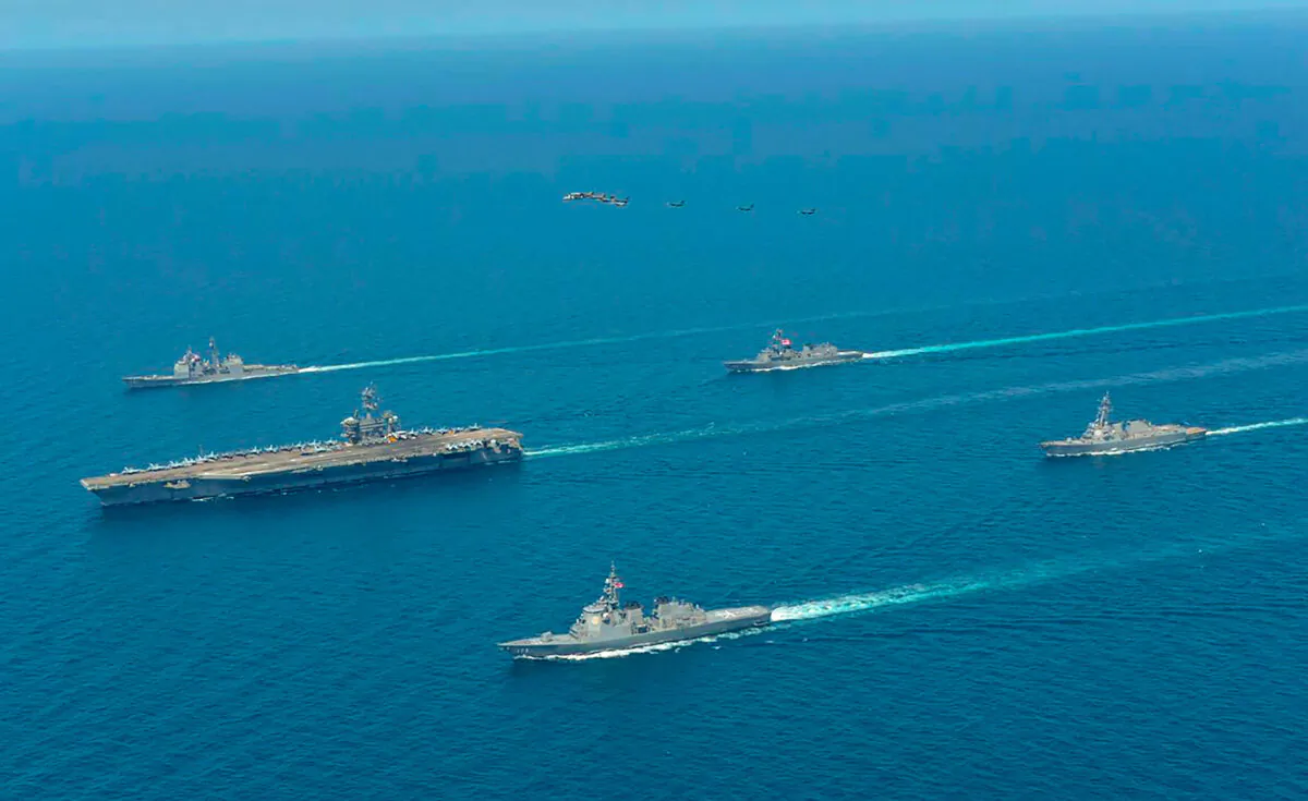 USS Abraham Lincoln (L), and JS Kongo (front), sail in formation during a U.S.–Japan bilateral exercise in the Sea of Japan on April 12, 2022. (Japan Maritime Self-Defense Force via AP)