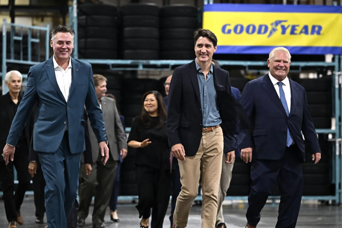 Mark Stewart (L), CEO and president of Goodyear, Prime Minister Justin Trudeau, and Premier of Ontario Doug Ford (R) arrive for an announcement at the Goodyear plant in Napanee, Ont., on Aug. 12, 2024. (The Canadian Press/Justin Tang)