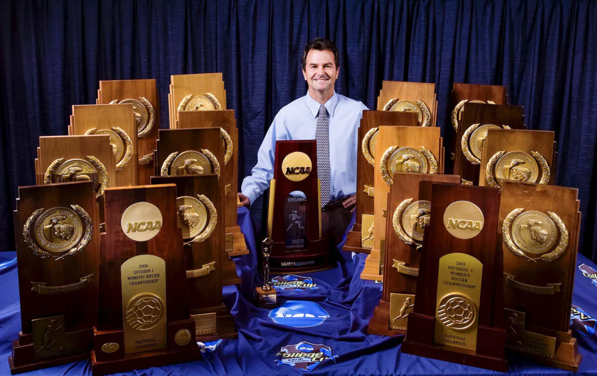 Anson Dorrance has decided to retire after 45 years leading the women’s soccer team at the University of North Carolina, holding all his championship trophies in Chapel Hill, N.C., in 2008. (Courtesy of UNC Athletics)