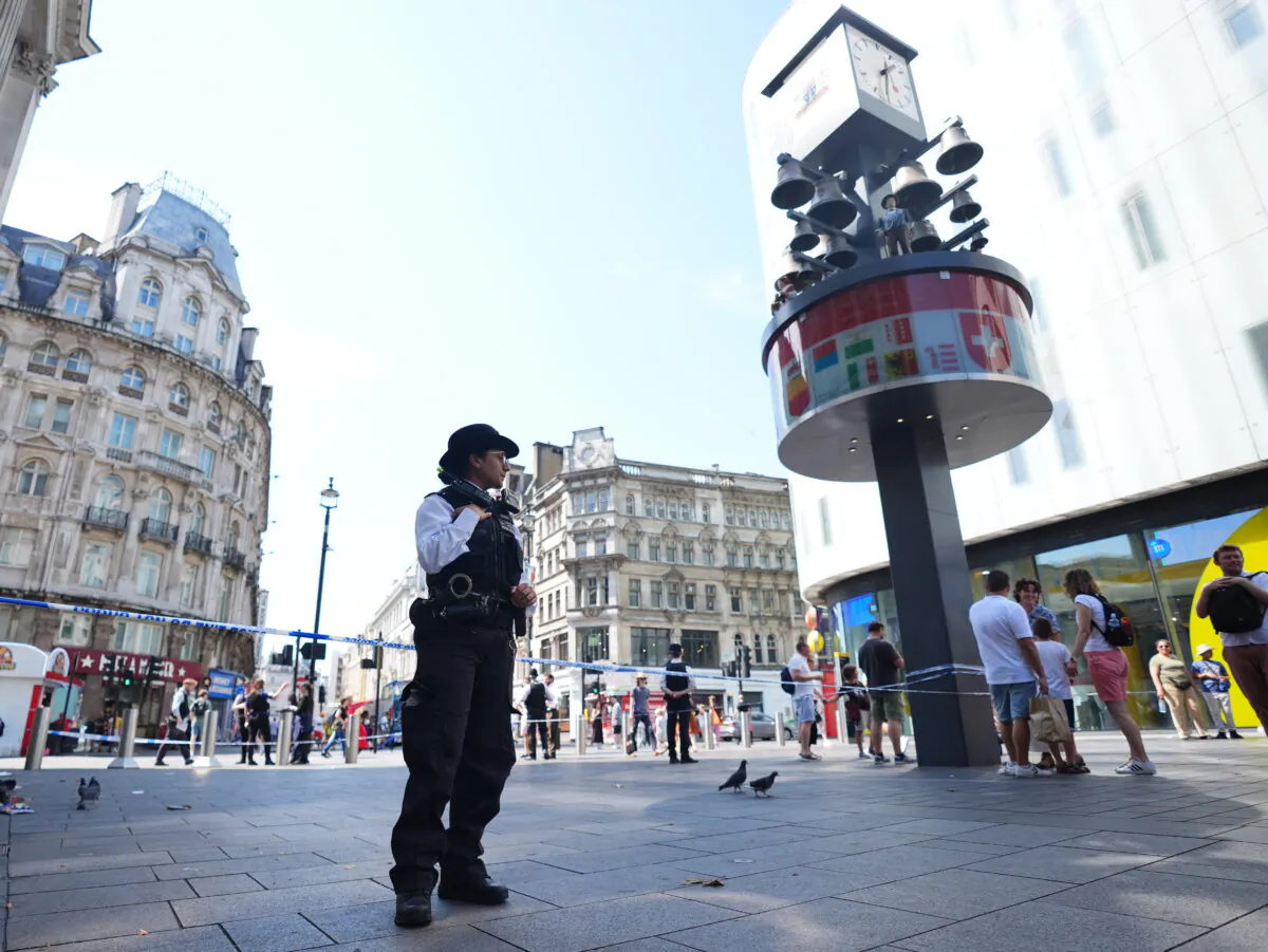 Police officers at the scene in Leicester Square, London, as a man has been arrested after an 11-year-old girl and 34-year-old woman were stabbed. (James Manning/PA Wire)
