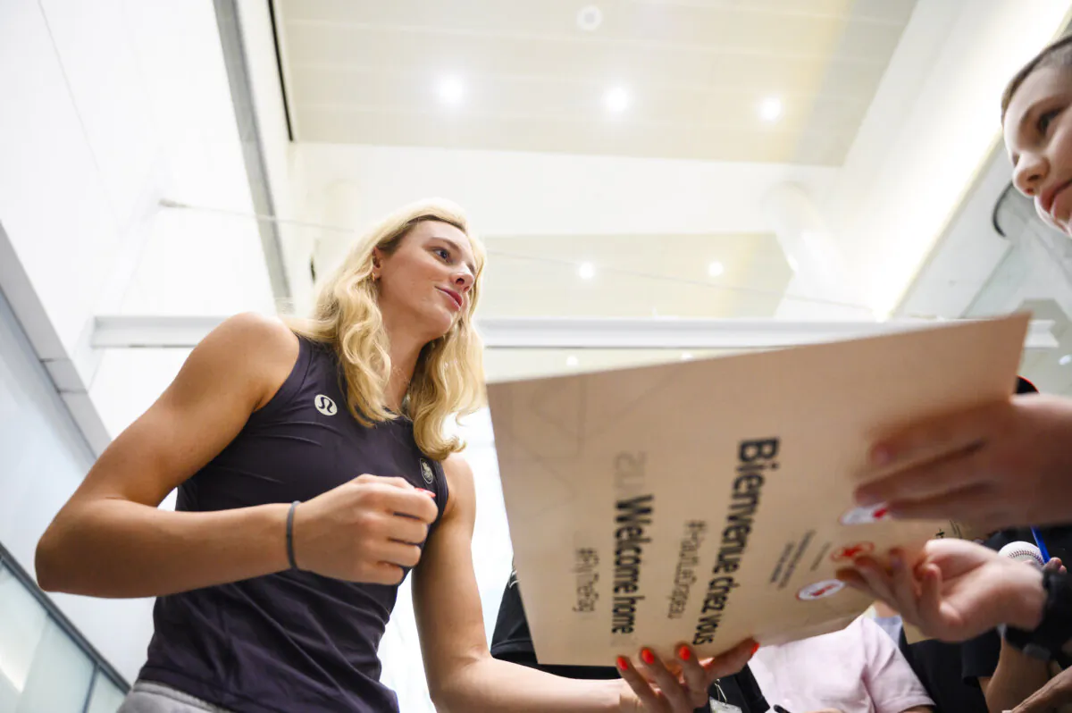 Olympic medalist Summer McIntosh signs autographs for fans after arriving at Pearson airport following the Paris 2024 Olympic Games, in Toronto, on Aug. 12, 2024. (The Canadian Press/Christopher Katsarov)