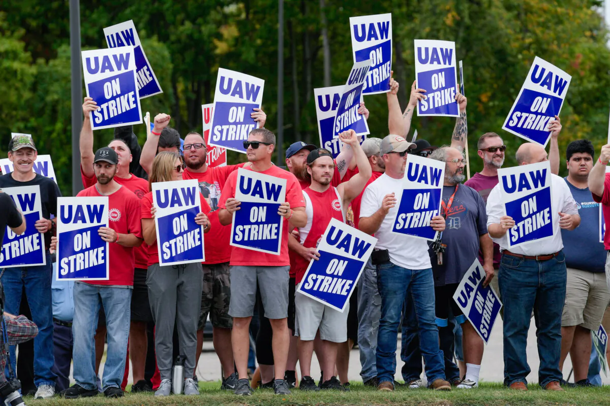 United Auto Workers members hold picket signs near a General Motors assembly plant in Delta Township, Mich., on Sept. 29, 2023. (Paul Sancya/AP Photo)