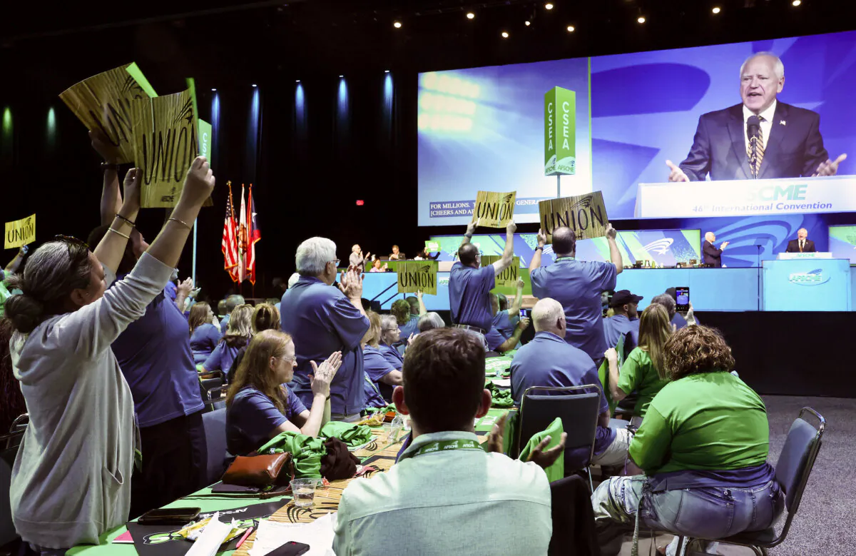 Attendees hold signs as Democratic vice presidential candidate Minnesota Governor Tim Walz speaks at the 46th International Convention of the American Federation of State, County and Municipal Employees (AFSCME) at the Los Angeles Convention Center in Los Angeles on Aug. 13, 2024. (Mario Tama/Getty Images)