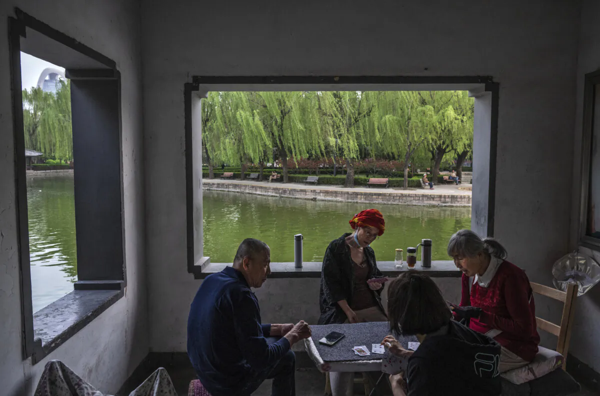 People play cards at a local park in Beijing on Apr. 18, 2024. (Kevin Frayer/Getty Images)