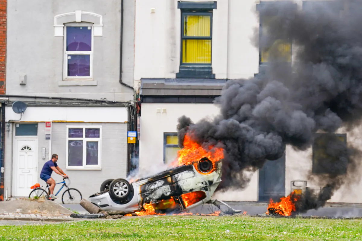 A car burns after being overturned during an anti-immigration protest in Middlesbrough, England, on Aug. 4, 2024. (Owen Humphreys/PA)