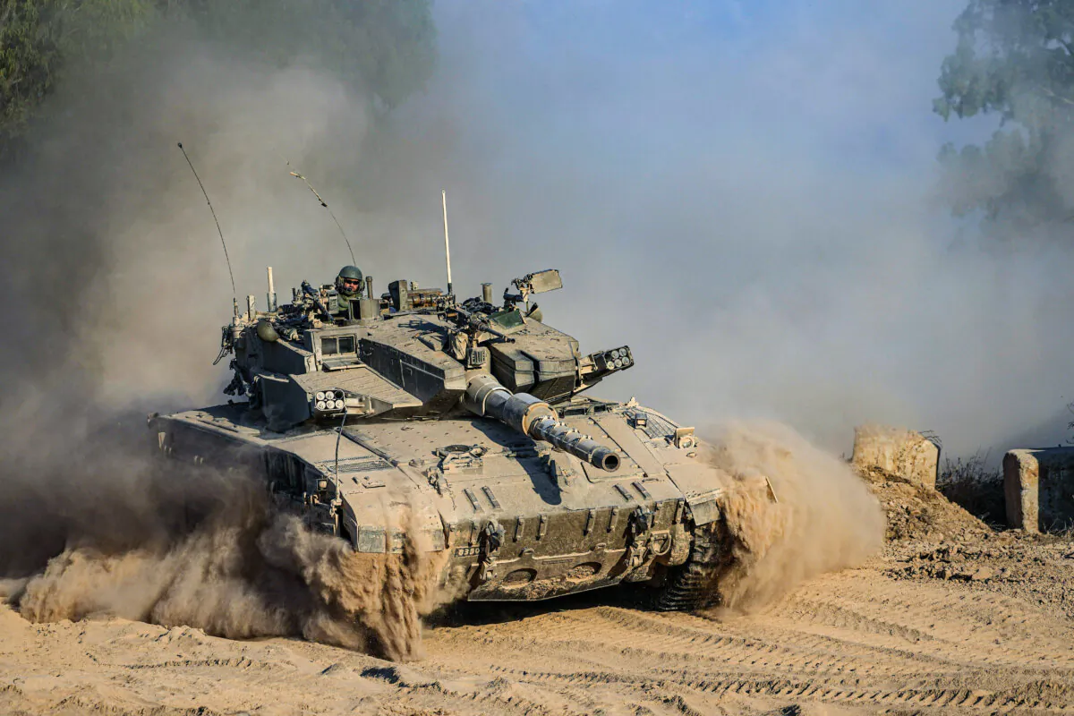 An Israeli soldier moves on the top of a tank near the Israeli-Gaza border, as seen from southern Israel, on July 14, 2024. (Tsafrir Abayov/AP Photo)