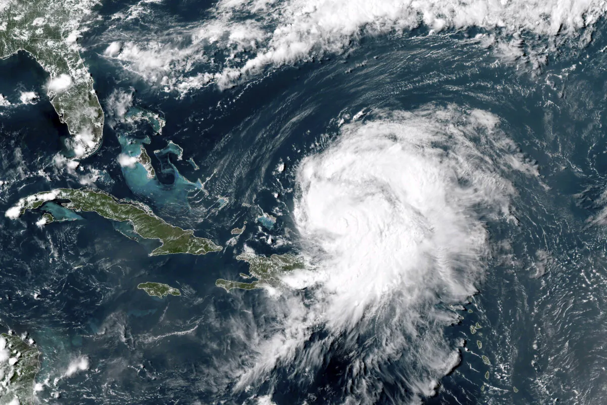 A satellite image shows Hurricane Ernesto northwest of San Juan, Puerto Rico, and moving over open waters, at at 4 p.m ET on Aug. 14, 2024. (NOAA via AP)