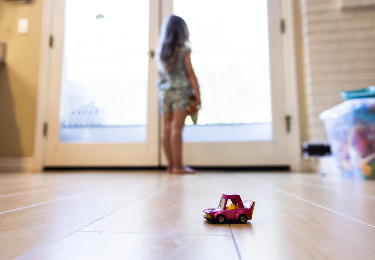 Becca, 5, who has been diagnosed with Alice in Wonderland Syndrome, looks out her window in the Los Angeles area in California on Aug. 13, 2024. (John Fredricks/The Epoch Times)