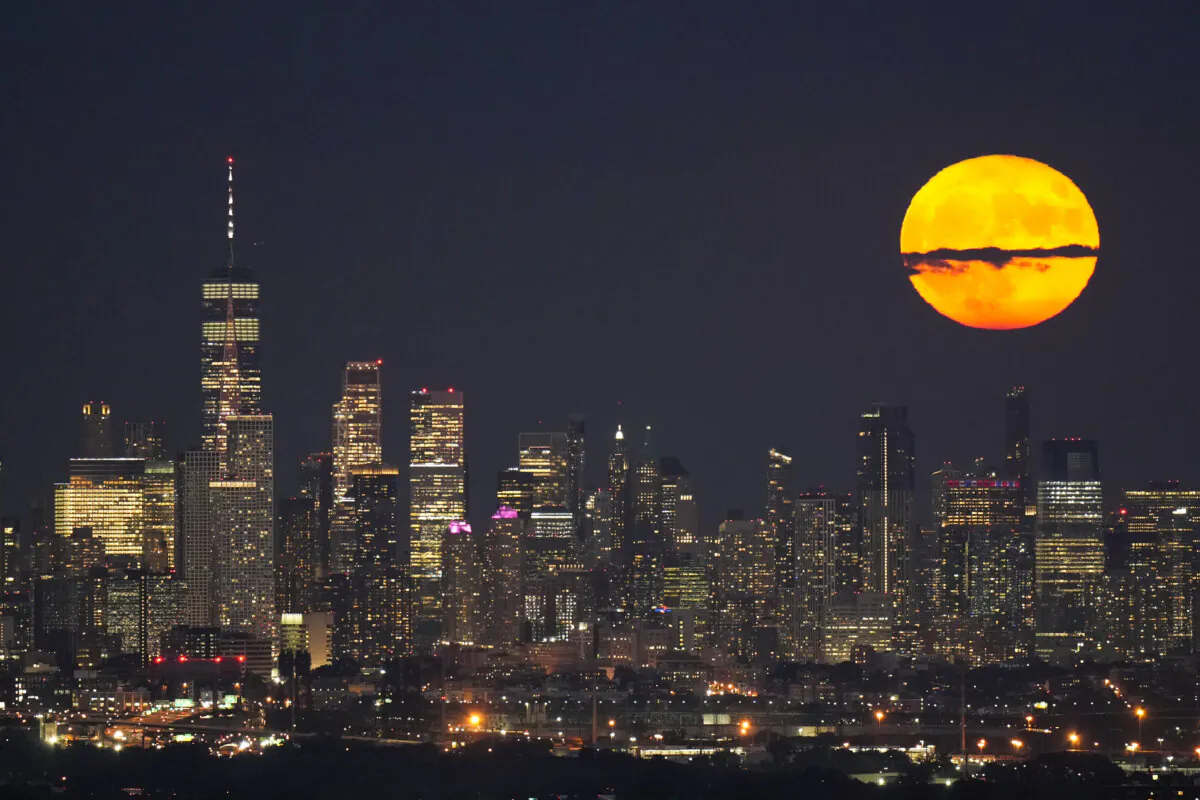 The moon rises through clouds over the skyline of lower Manhattan in this view from West Orange, N.J., Tuesday, Aug. 1, 2023, during a supermoon period. (AP Photo/Seth Wenig)