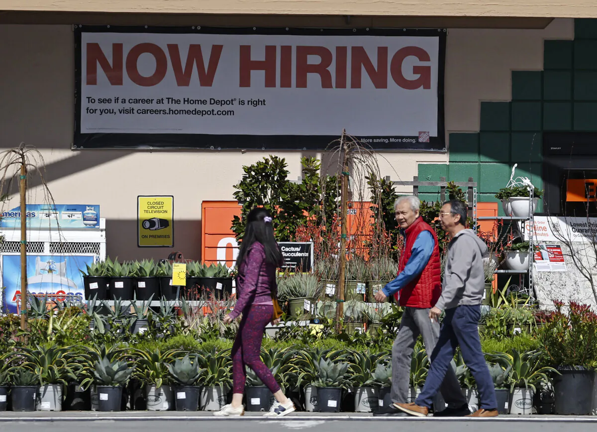 Home Depot customers walk by a posted "Now Hiring" sign in San Rafael, Calif., on March 8, 2024. (Justin Sullivan/Getty Images)