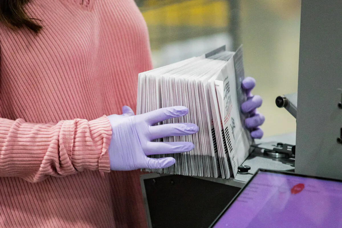 An election worker holds ballots in Pomona, Calif., in a file photograph. (John Fredricks/The Epoch Times)