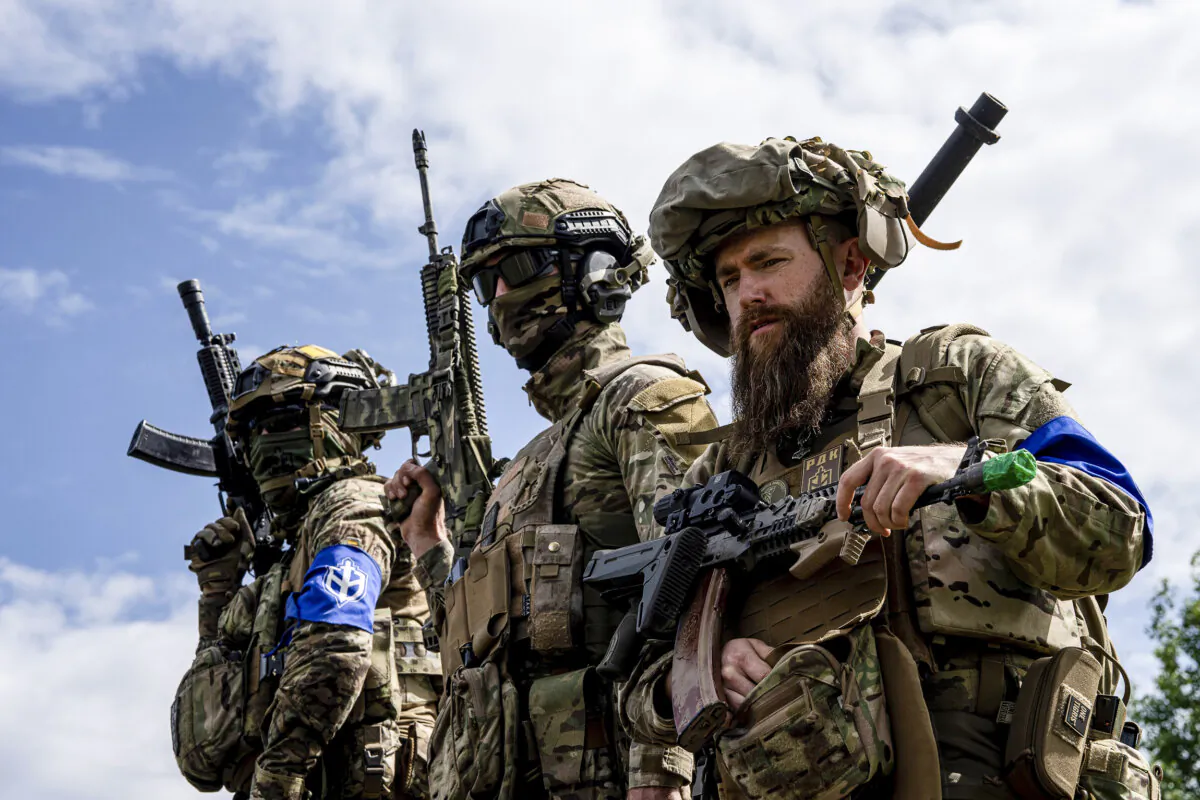 Fighters of Russian Volunteer Corps stand atop on an APC during press conference not far from the Ukraine's border with Russia in Sumy region, Ukraine, on May 24, 2023. (Evgeniy Maloletka/AP Photo)