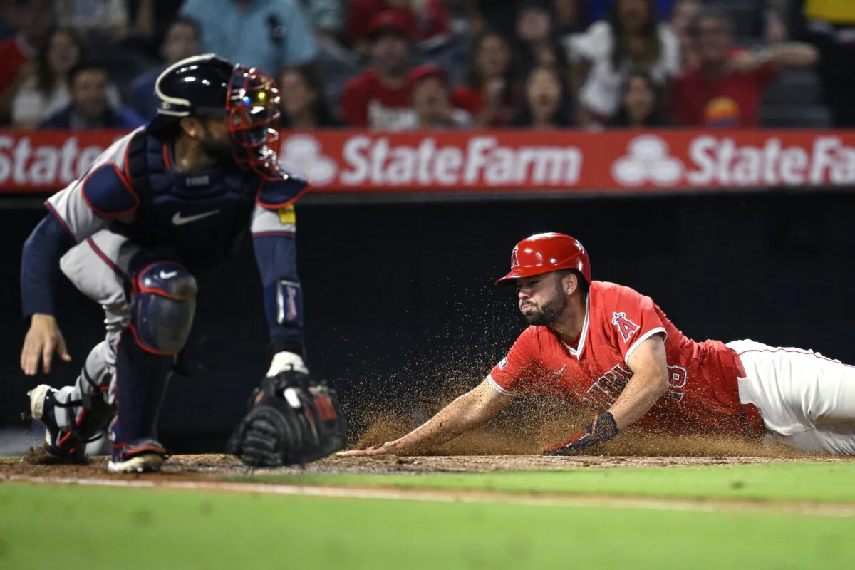Nolan Schanuel (18) of the Los Angeles Angels slides home to score a run ahead of the throw to Travis d'Arnaud (16) of the Atlanta Braves during the sixth inning in Anaheim, Calif., on August 17, 2024. (Orlando Ramirez/Getty Images)