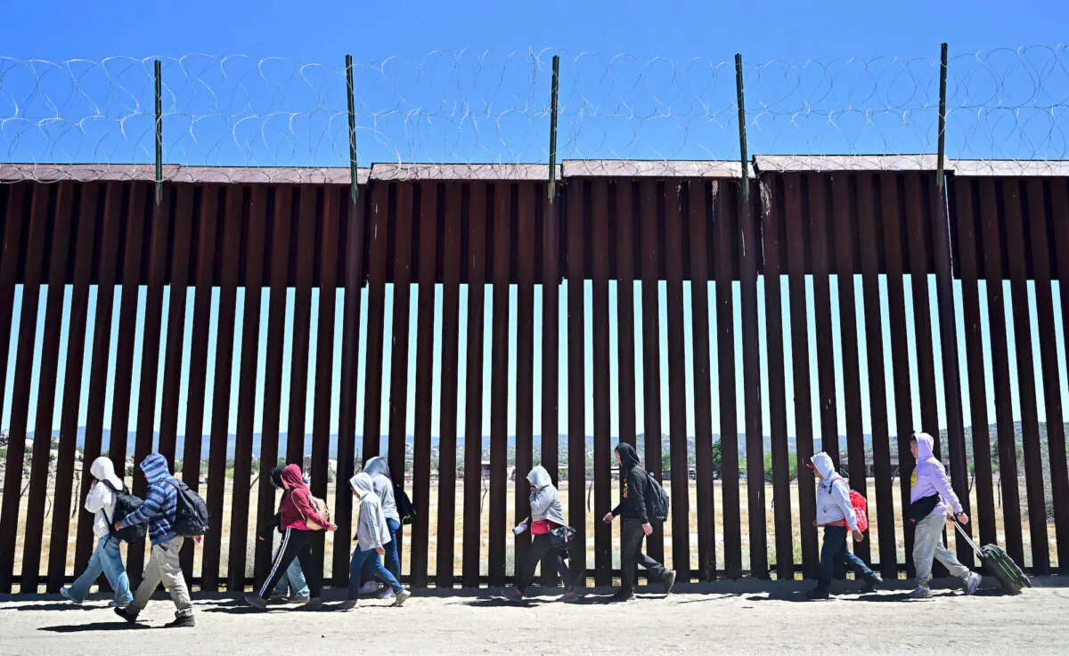 Illegal immigrants walk on the U.S. side of the border wall in Jacumba Hot Springs, Calif., after crossing from Mexico on June 5, 2024. (Frederic J. Brown/AFP via Getty Images)