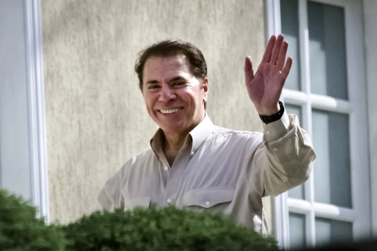 Brazilian TV mogul Silvio Santos waves from outside his home in Sao Paulo, Brazil on Aug. 30, 2001. (Dario Lopez-Mills/AP Photo)