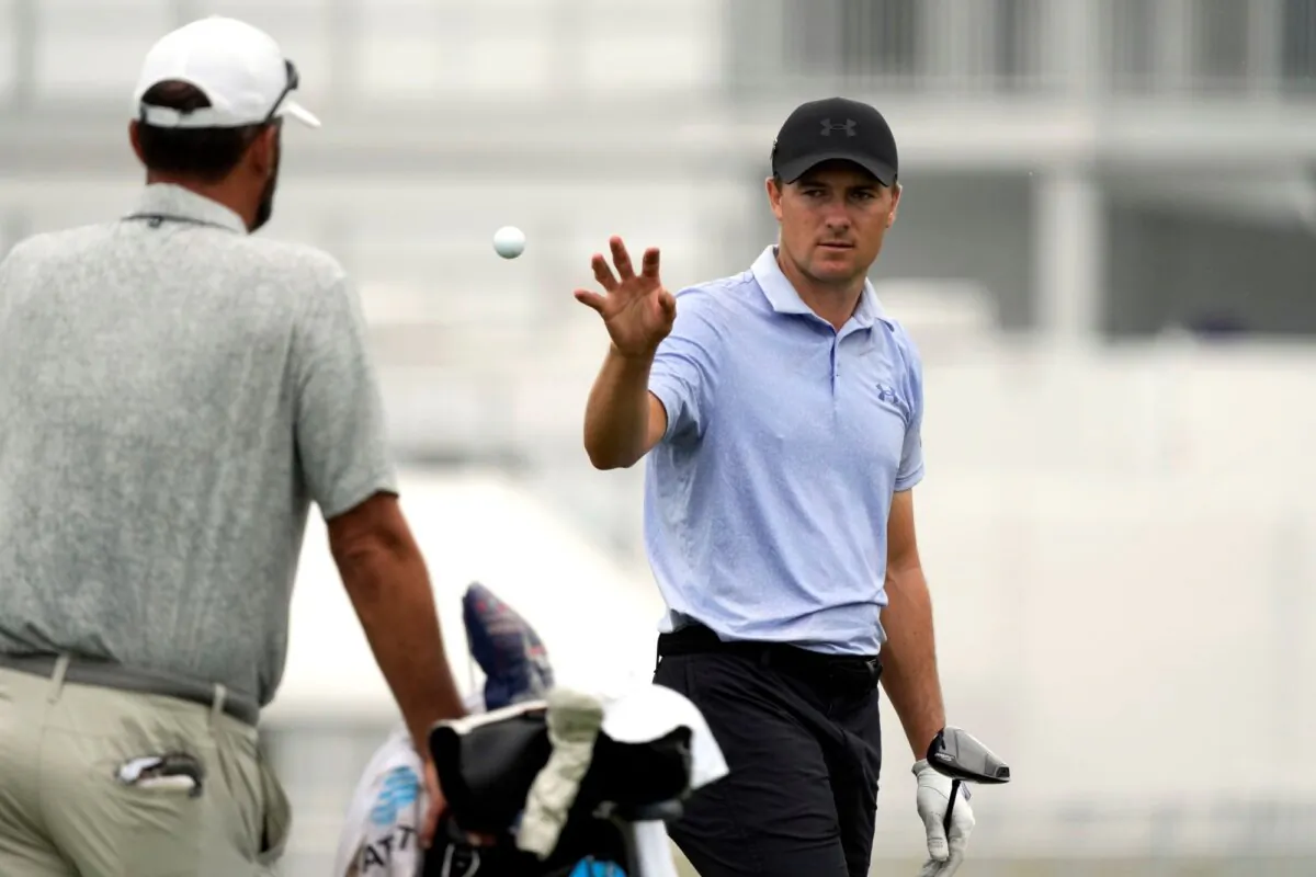 Jordan Spieth (R) catches a ball tossed to him on the driving range at the St. Jude Championship in Memphis, Tenn., on Aug. 14, 2024, (Mark Humphrey/AP Photo)