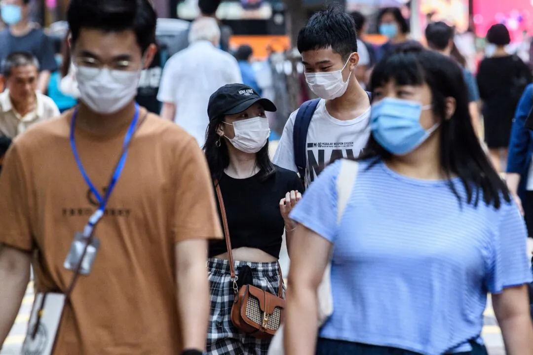 Pedestrians wear face masks, in this file photo. (Anthony Wallace/AFP via Getty Images)
