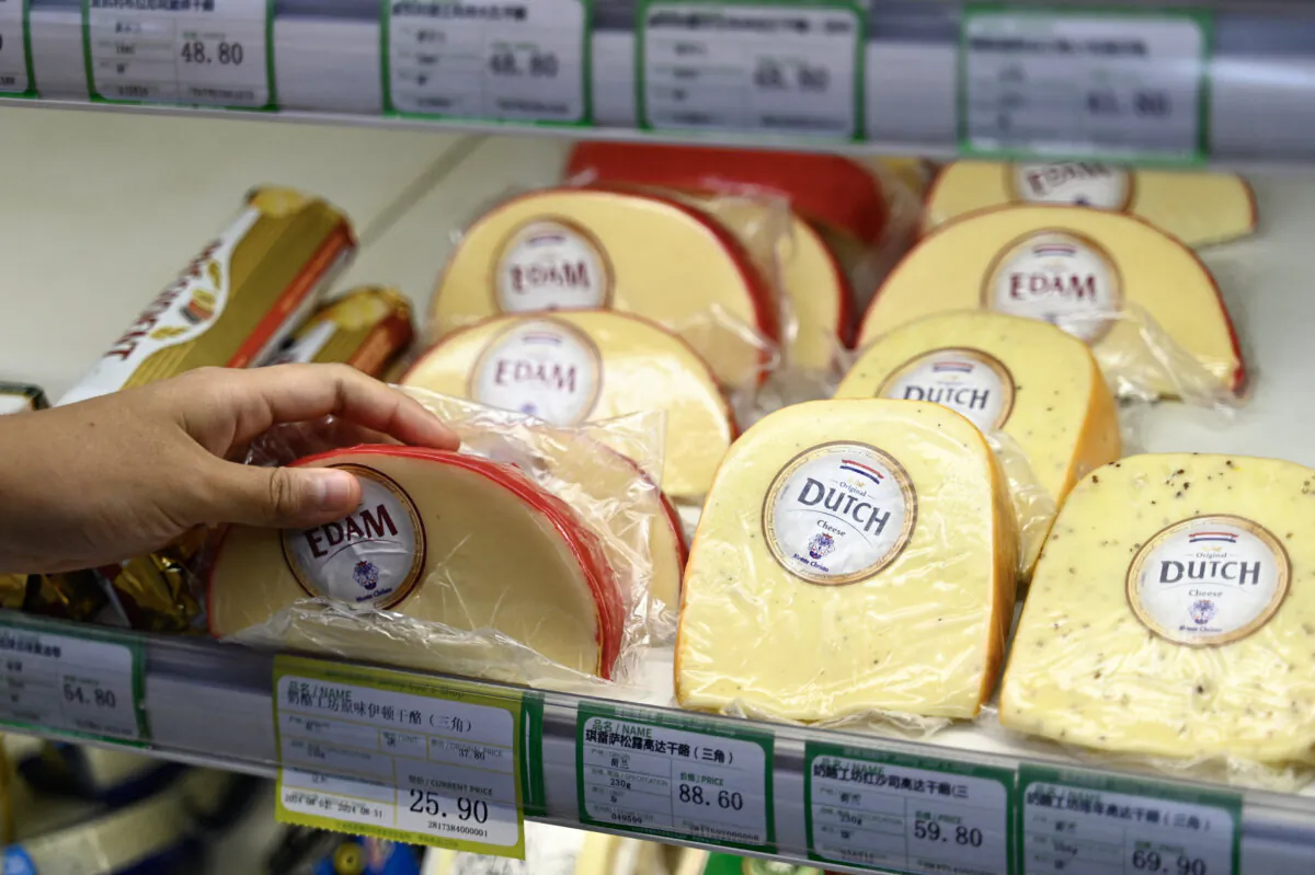 A customer picks up a cheese imported from Europe at a supermarket in Beijing on Aug. 21, 2024. (Pedro Pardo/AFP via Getty Images)
