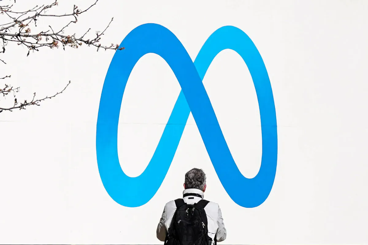 A person stands in front of a Meta sign outside of the company's headquarters in Menlo Park, Calif., March 7, 2023. (Jeff Chiu/AP Photo)