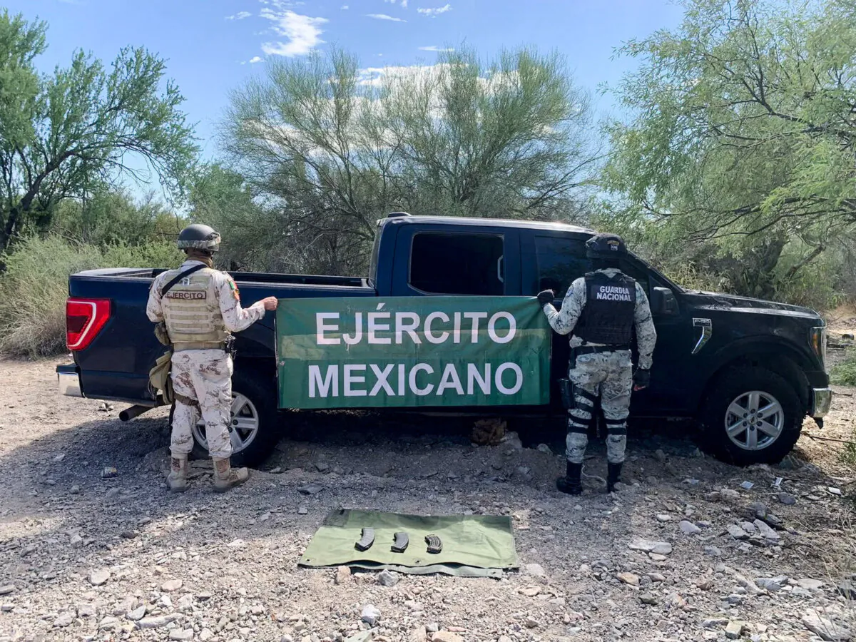 Mexican soldiers hold a banner reading "Mexican Army" next to a vehicle reported as stolen and used by gunmen near the site where two elderly women were shot dead at a highway in Mexico's northern Sonora state, in this undated handout distributed to Reuters on August 23, 2024. (Fiscalia General del Estado de Sonora (FGJES)/Handout via REUTERS)