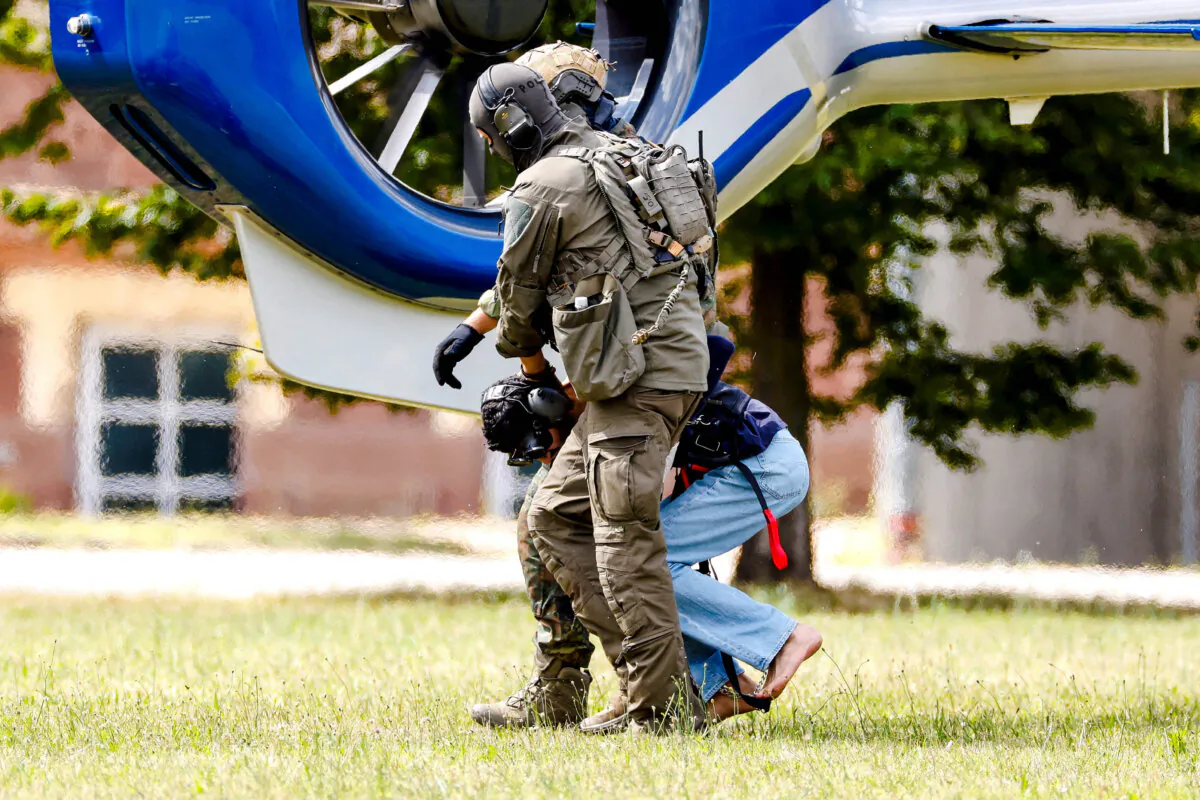 A man accused of a knife attack in Solingen on August 23, is escorted by police in Karlsruhe, Germany, on Aug. 25, 2024. (Heiko Becker/Reuters)
