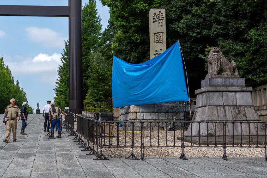 A blue sheet obscures the stone pillar which bears the name of the Yasukuni Shrine, after graffiti was found on the structure at the entrance to the shrine in Tokyo on Aug. 19, 2024. (Kazuhiro Nogi/AFP via Getty Images)