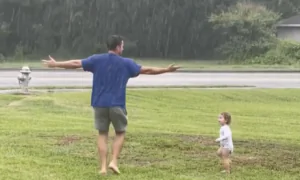 Dad and Toddler Dance Together in the Rain
