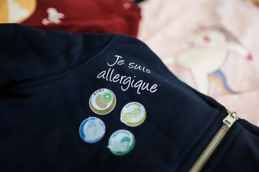 T-shirts by the ALRJ brand with customizable logos warning about children's allergies, such as peanuts, nuts, cow's milk, seafood, and gluten, in Cenon, southwestern France, on June 29, 2021. (Thibaud Moritz/AFP via Getty Images)