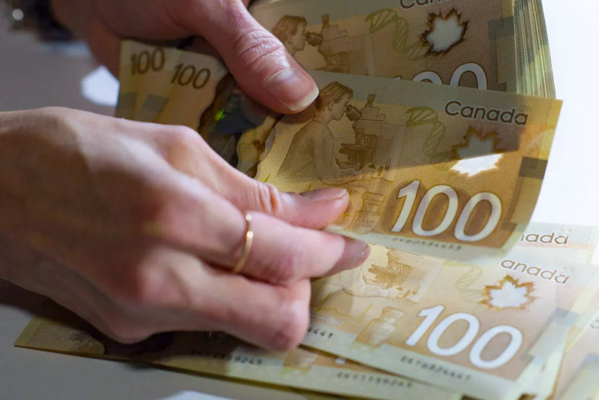 Canadian $100 bills are counted in Toronto in a file photo. (The Canadian Press/Graeme Roy)