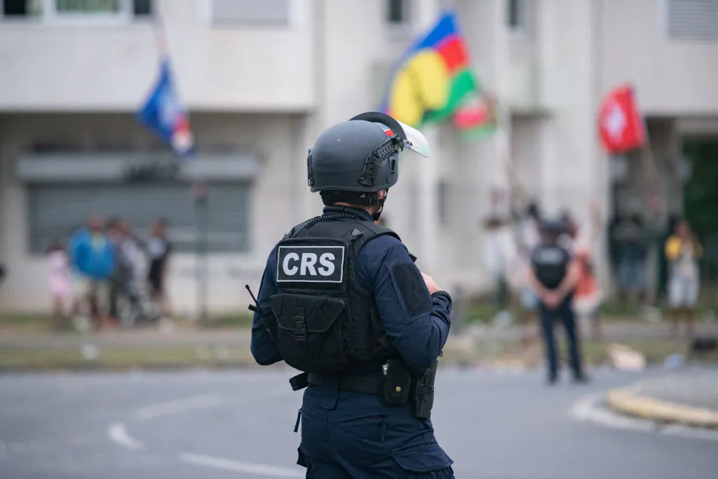 A French Republican Security Corps (CRS) riot police officer stands in front of pro-independence supporters in Noumea, New Caledonia, on July 11, 2024. (Delphine Mayeur/AFP via Getty Images)