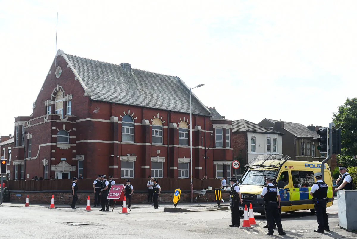 Police stand guard outside the Islamic Society Mosque in Southport, northwest England, on July 31, 2024, a day after protests targeted the mosque following a knife attack that left three children dead. (Peter Powell/AFP via Getty Images)