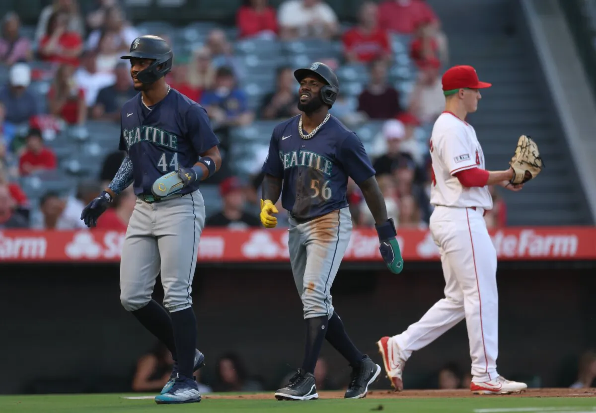 Randy Arozarena (56) and Julio Rodríguez (44) of the Seattle Mariners react to their runs behind Samuel Aldegheri (66) of the Los Angeles Angels after an error from Zach Neto (9) during the first inning in Anaheim, Calif., on Aug. 30, 2024. (Harry How/Getty Images)