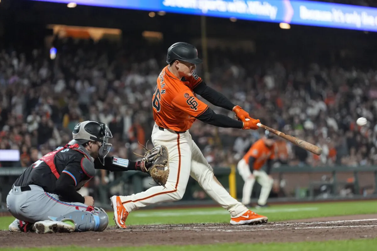 San Francisco Giants' Matt Chapman (R) hits a three run-double in front of Miami Marlins catcher Nick Fortes during the eighth inning of a baseball game in San Francisco on Aug. 30, 2024. (Jeff Chiu/AP Photo)