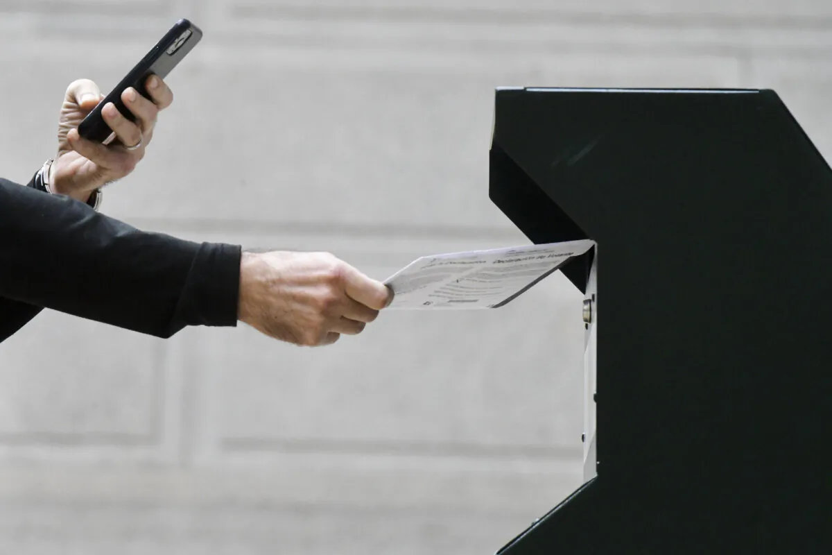 A man photographs himself depositing his ballot in an official ballot drop box at Philadelphia City Hall on Oct. 27, 2020. (Mark Makela/Getty Images)