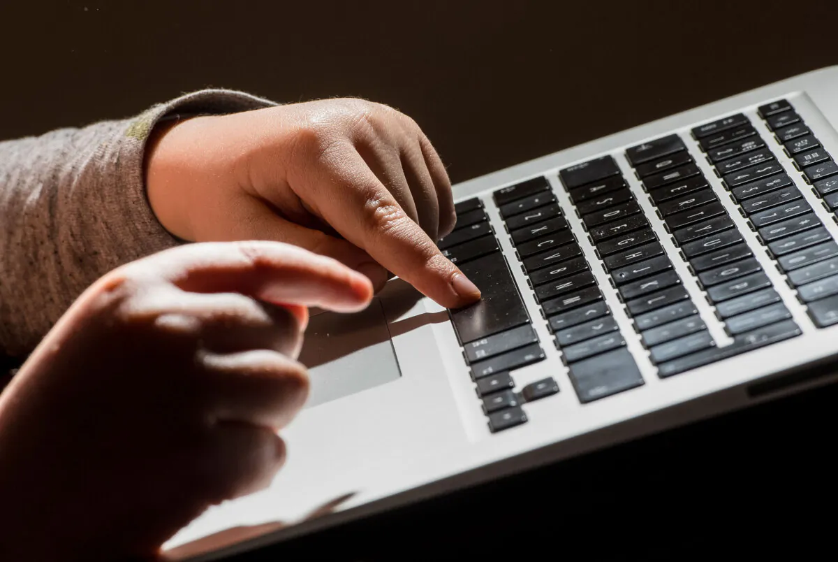 File photograph of a child using a laptop computer, on May 26, 2022. (Dominic Lipinski/PA Media)
